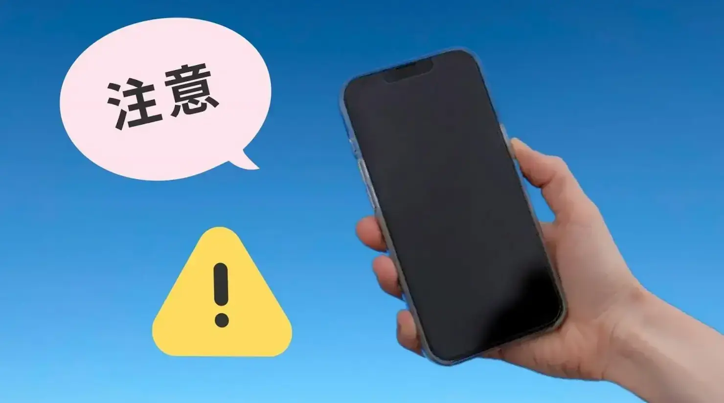 携帯電話を手に持ち「注意」の文字